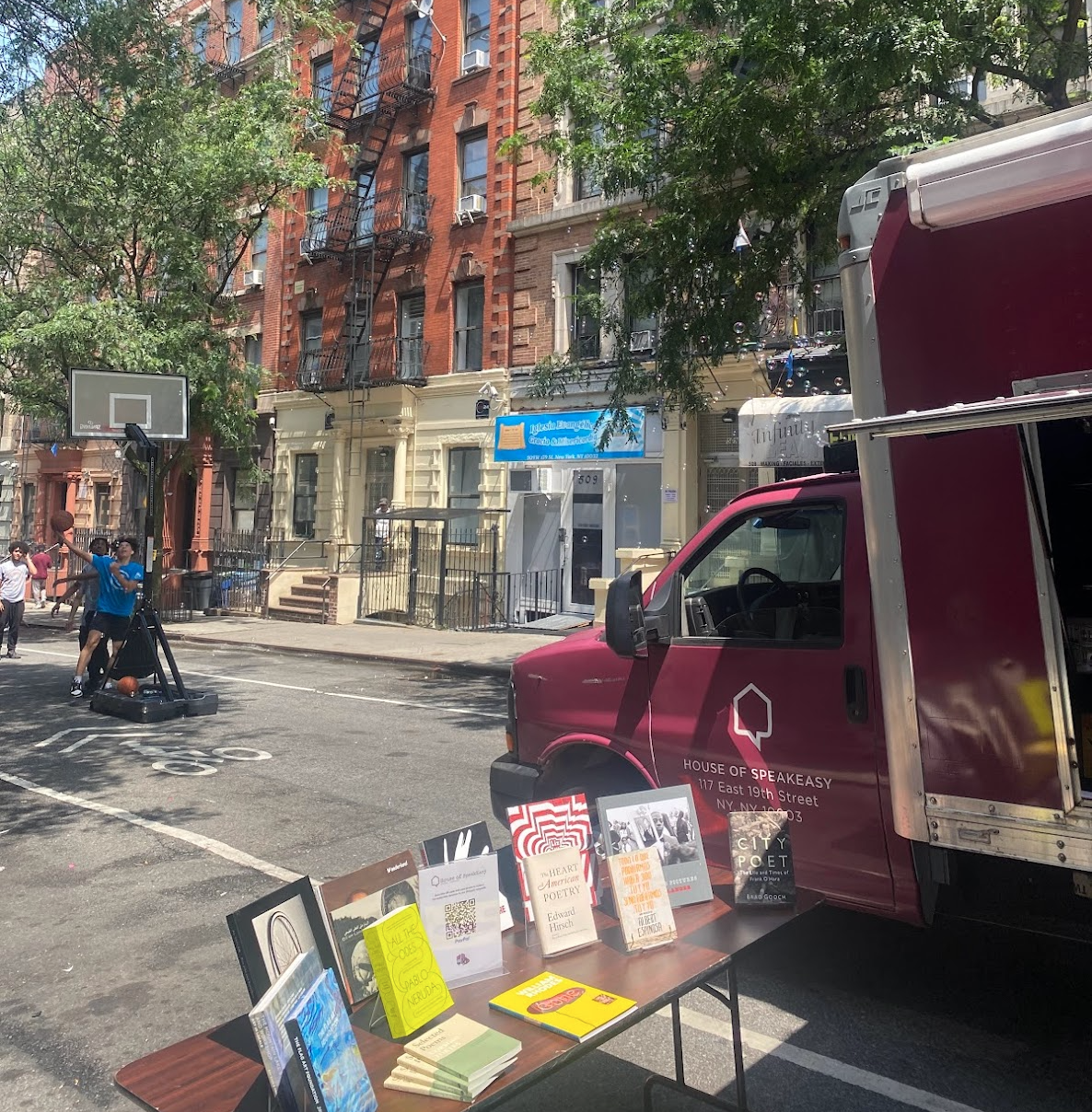 A crowd of young children gathers around House of SpeakEasy's Bookmobile