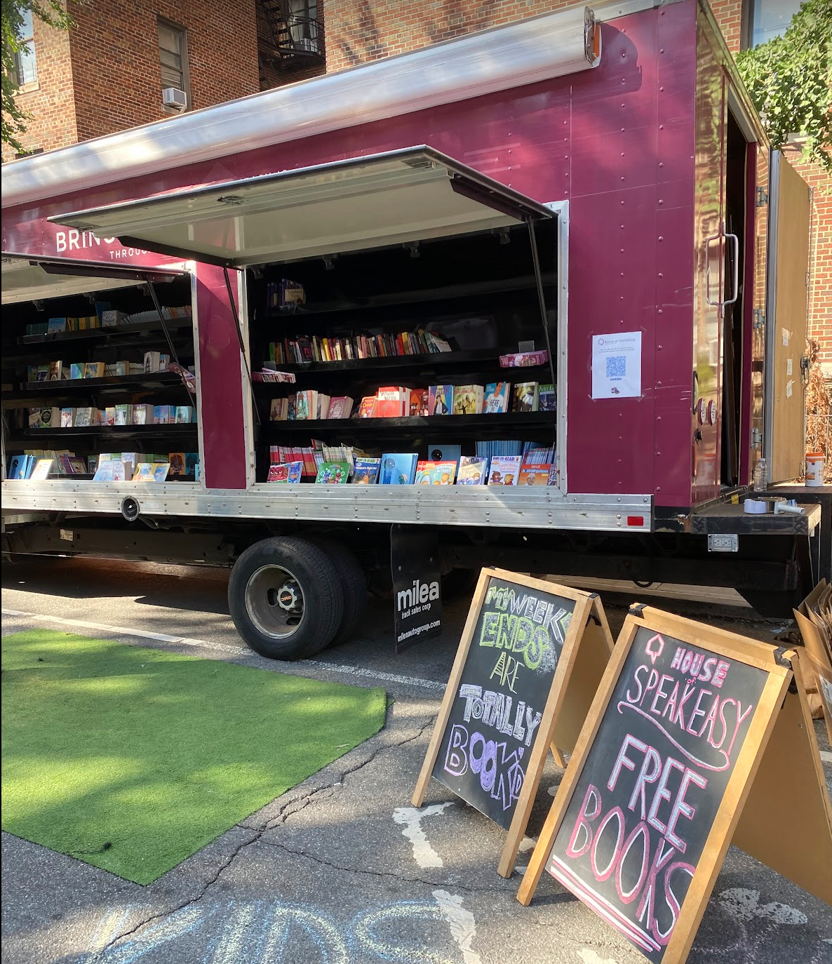 A crowd of young children gathers around House of SpeakEasy's Bookmobile