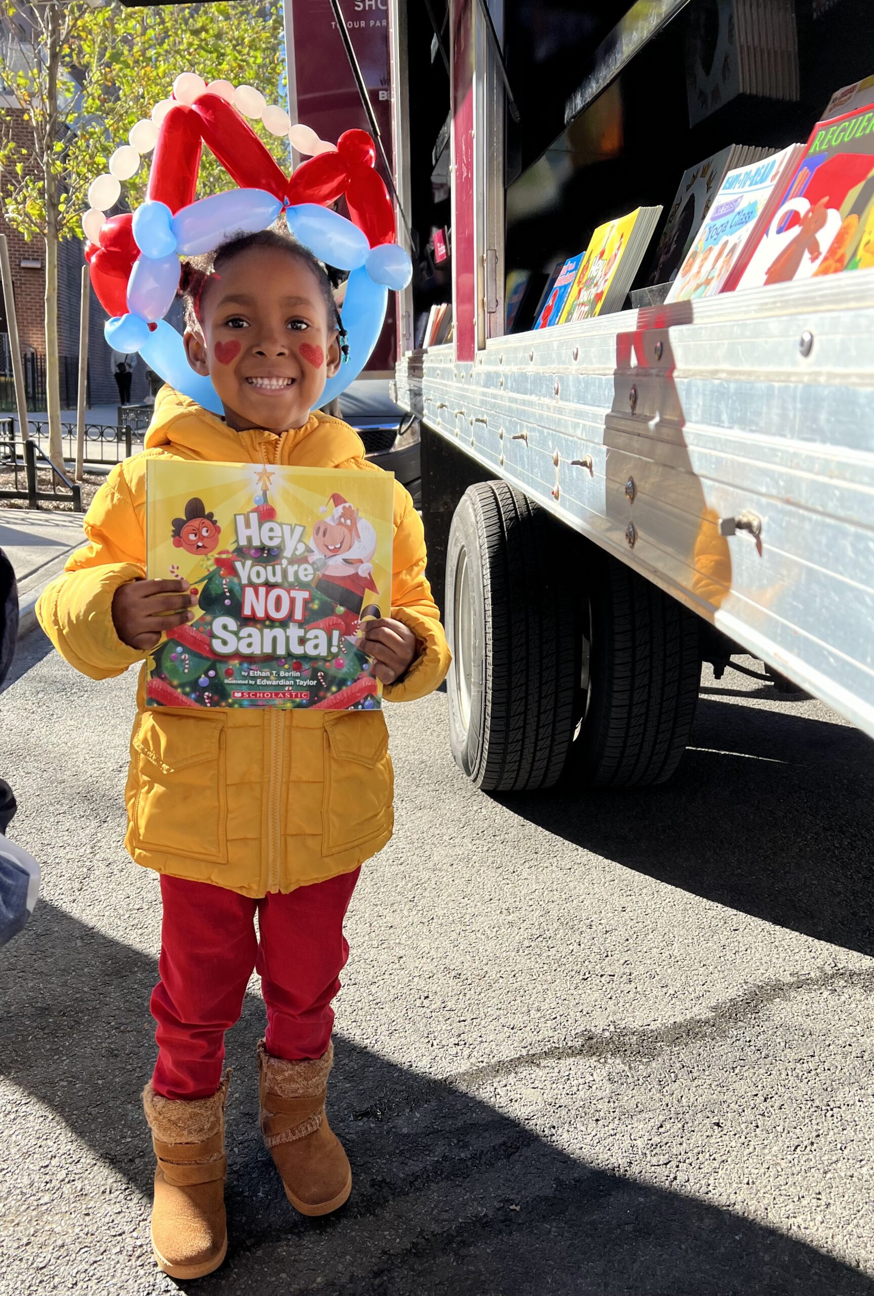 A crowd of young children gathers around House of SpeakEasy's Bookmobile