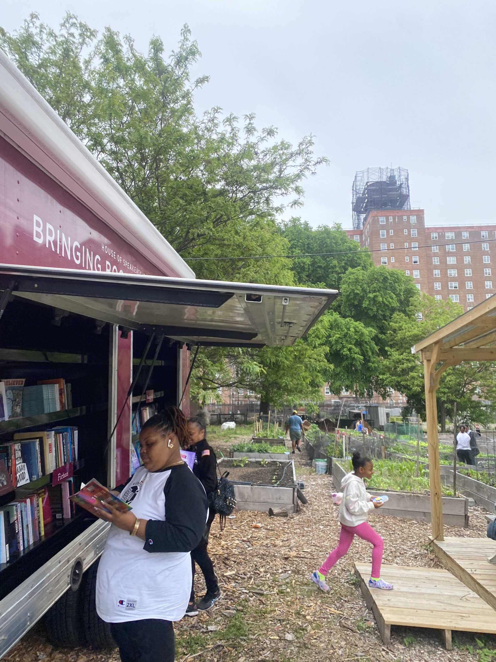 A crowd of young children gathers around House of SpeakEasy's Bookmobile